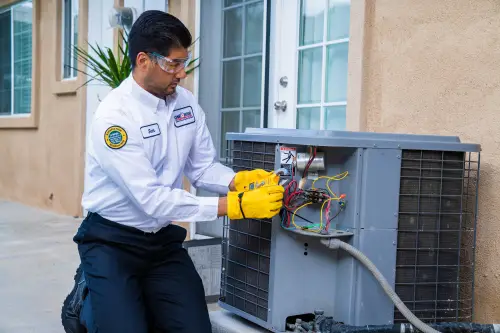 One Hour AC Tech, Jose, working with a clamp meter on an outside unit at a home in Lakeland, FL